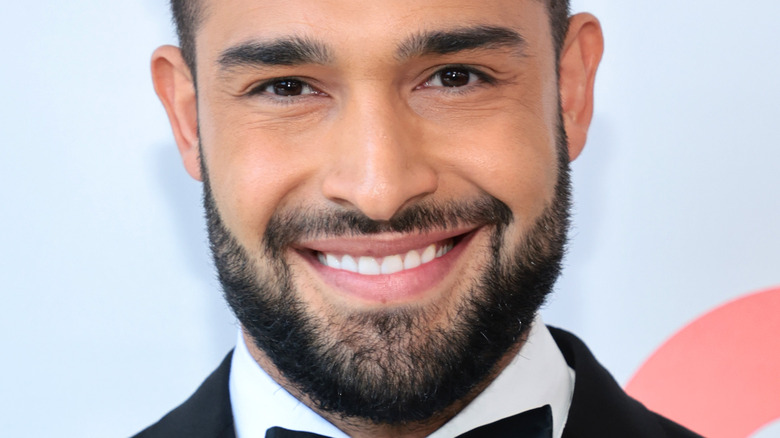 Sam Asghari smiles in a tux