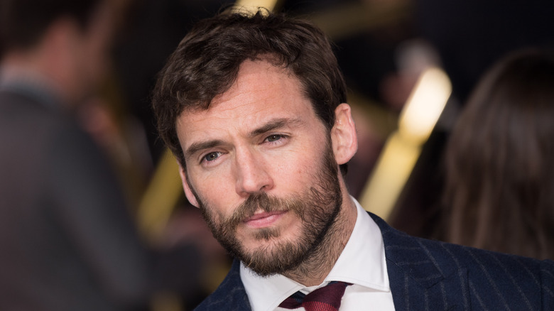 Sam Claflin squinting at event