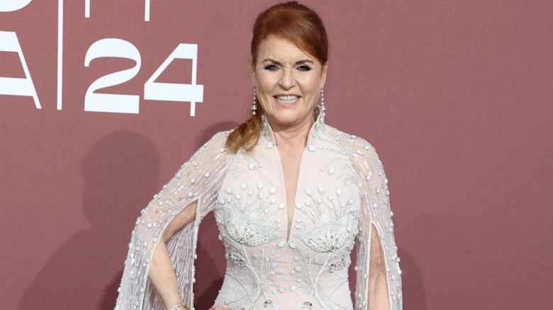 Sarah Ferguson smiling while posing in a white bejeweled dress