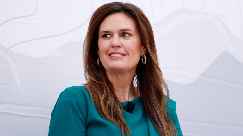 Sarah Huckabee Sanders smiling in a green dress