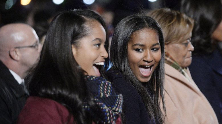 Sasha and Malia Obama laugh together during 2015 White House Christmas event