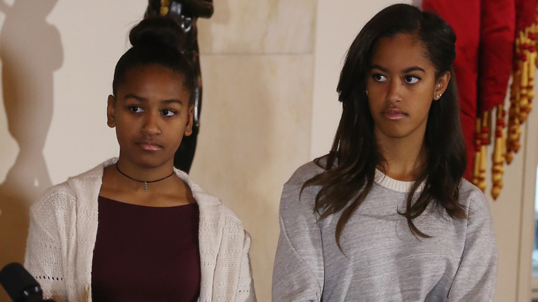 Sasha and Malia Obama with solemn expressions at the 2014 turkey pardoning