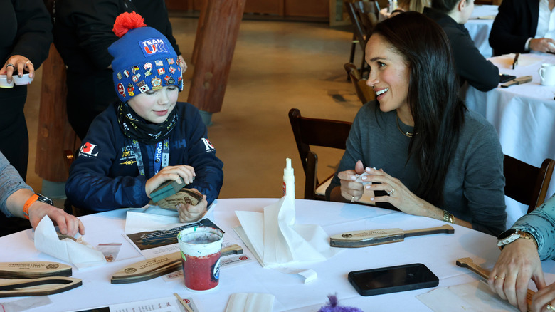 Meghan Markle at a table with a child