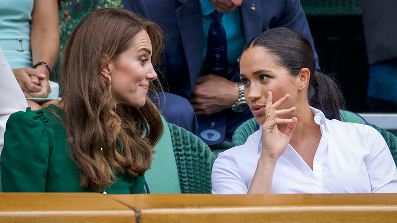 Kate Middleton and Meghan Markle look at each other at Wimbledon