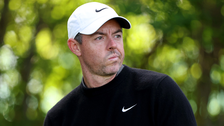 Rory McIlroy appears pensive on the golf course.