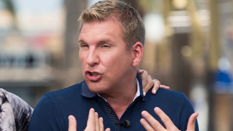 Todd Chrisley speaking with his hands raised to his chest