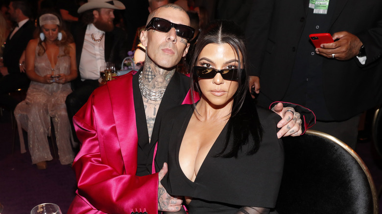 Travis Barker with arm around Kourtney Kardashian