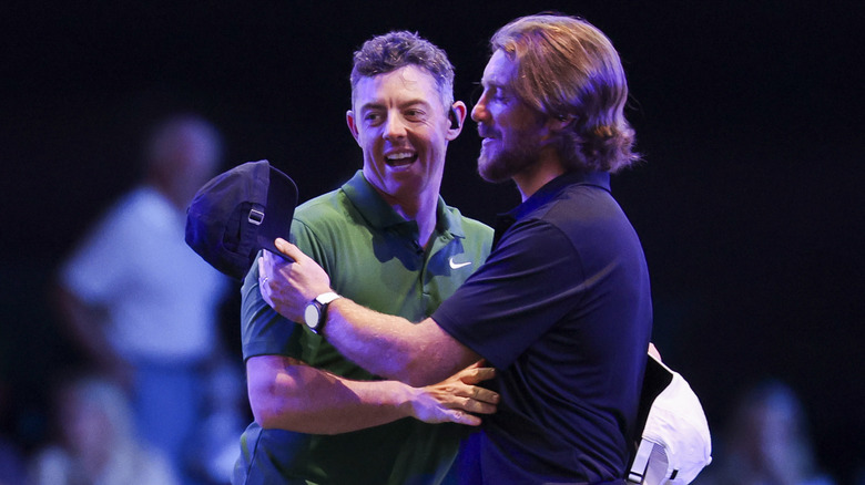 Rory McIlroy and Tommy Fleetwood laughing and hugging.