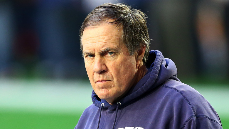Scowling Bill Belichick wearing hoodie