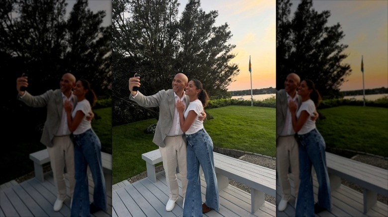 Alexis Lewis and Cory Booker taking a selfie outside on a wooden deck