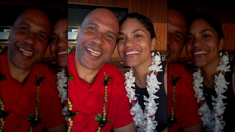 Alexis Lewis and Cory Booker resting their heads together and wearing leis