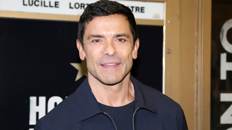 Mark Consuelos posing for cameras in navy jacket