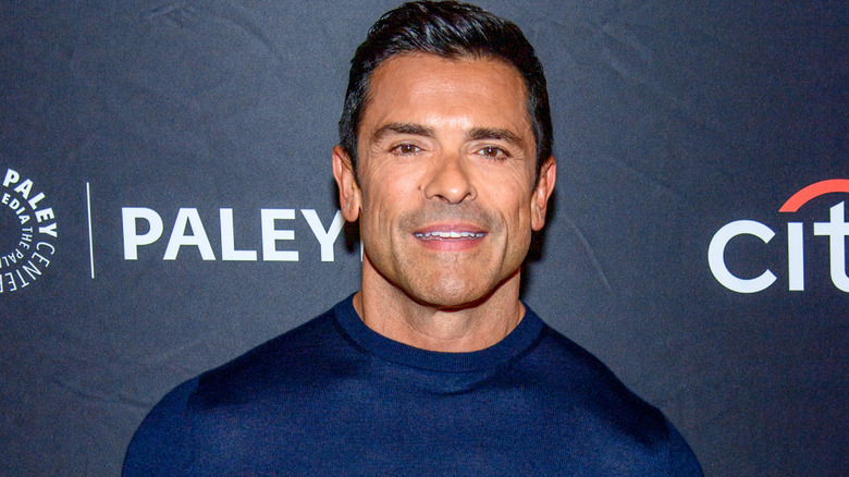 Mark Consuelos posing for cameras in dark blue sweater
