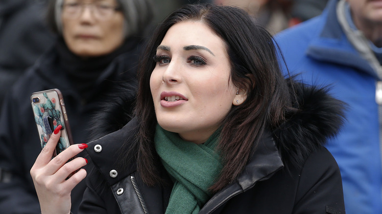 Laura Loomer holding her phone