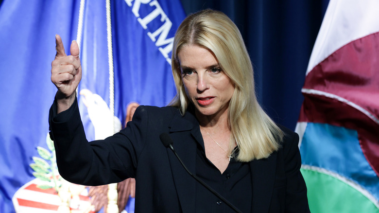 Pam Bondi pointing in front of flags
