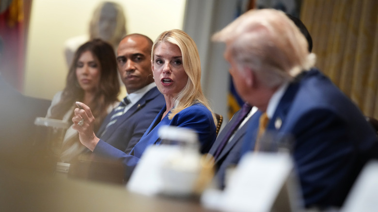 Pam Bondi speaking at a table with Donald Trump