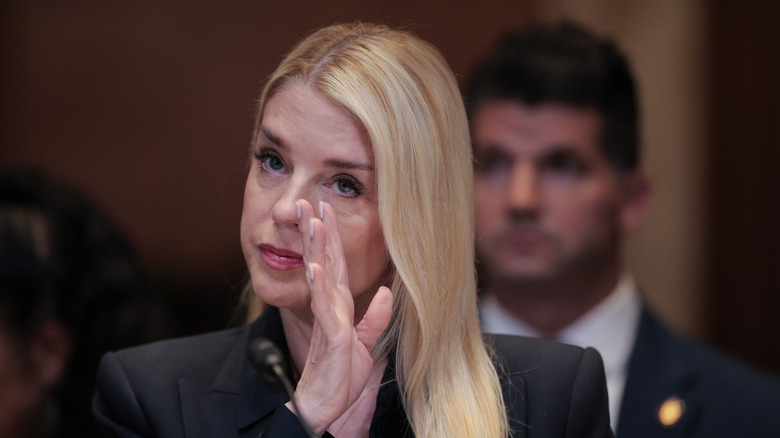 Pam Bondi blocking her face with her hand