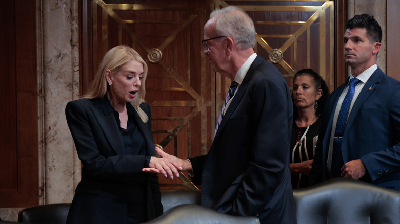 Pam Bondi shakes hands with a senator