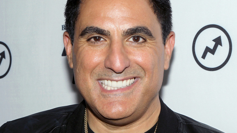 Reza Farahan smiling at a red carpet event