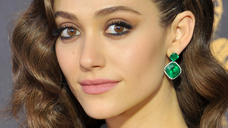 Emmy Rossum smiling and wearing green earrings