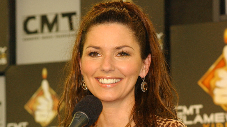 Shania Twain smiling at a microphone