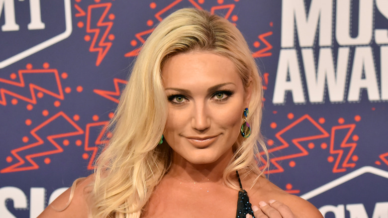 Brooke Hogan poses with her hair styled in a side part with a soft wave in 2019.