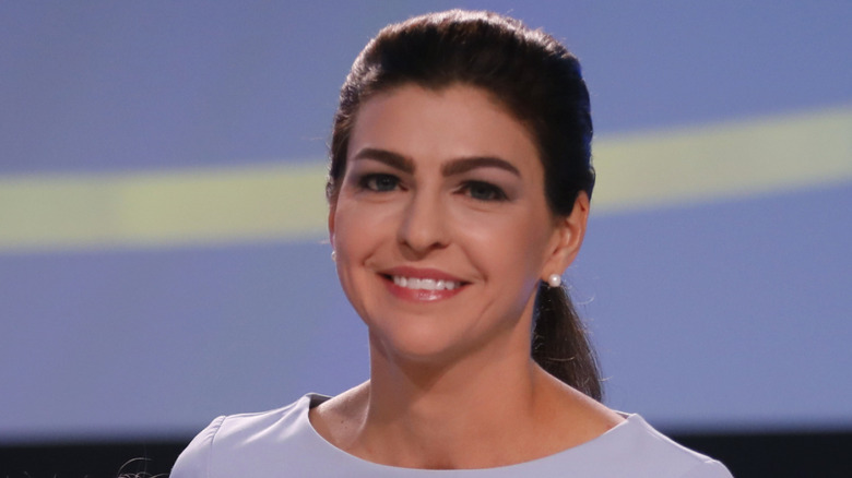 Casey DeSantis wearing a lilac dress while smiling on stage