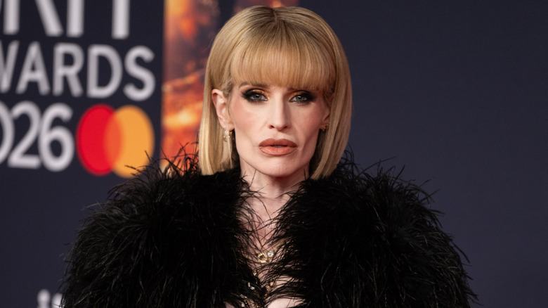 Kelly Osbourne posing in black feathery outfit