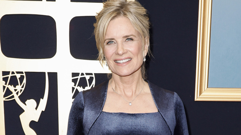Mary Beth Evans smiling at a red carpet event with her hair up and wearing a blue outfit.