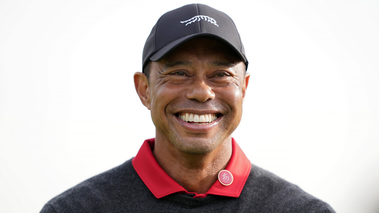 Tiger Woods smiles in a hat in 2025