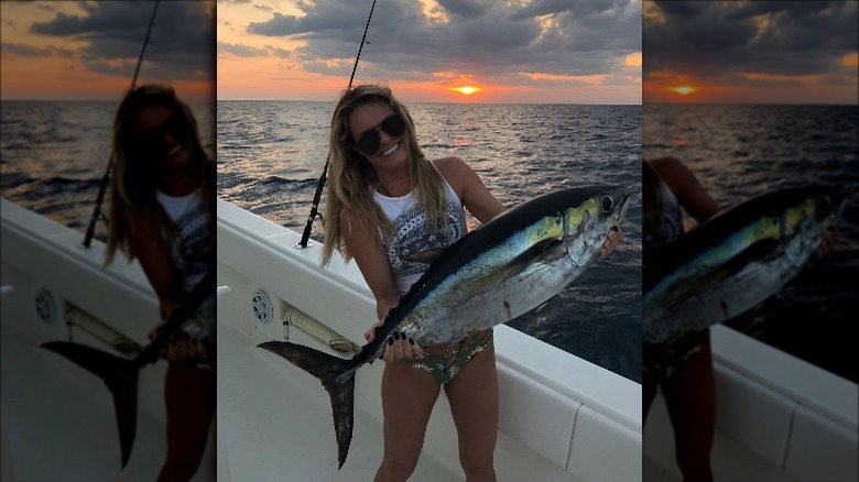 Juliette Porter carries a fish on a boat