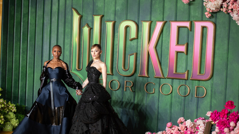 Ariana Grande and Cynthia Erivo in front of Wicked sign