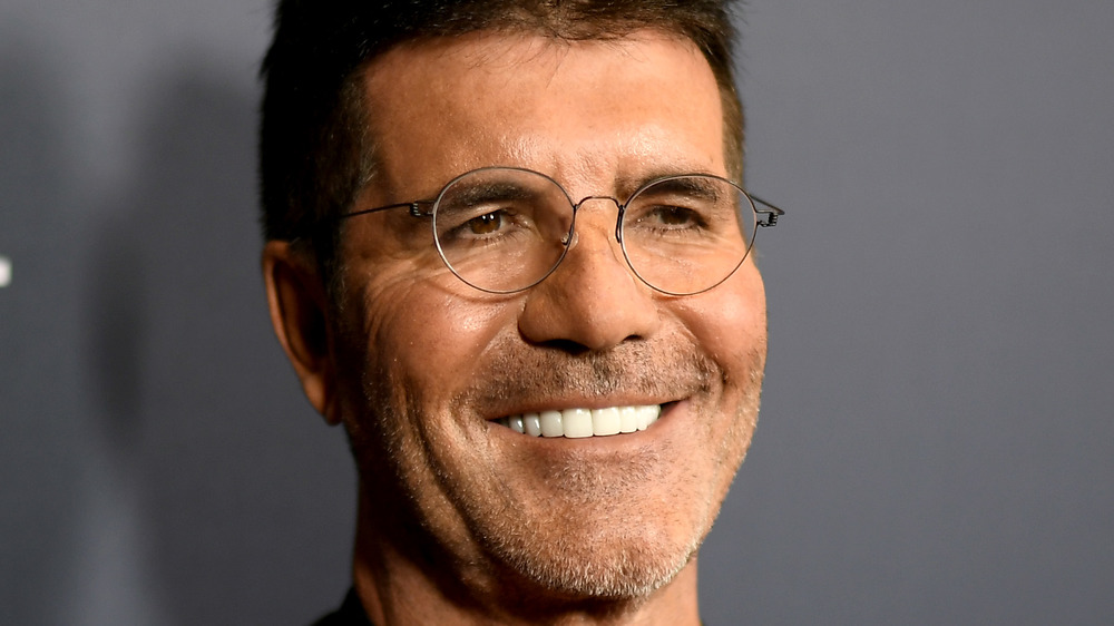 Simon Cowell smiling in glasses