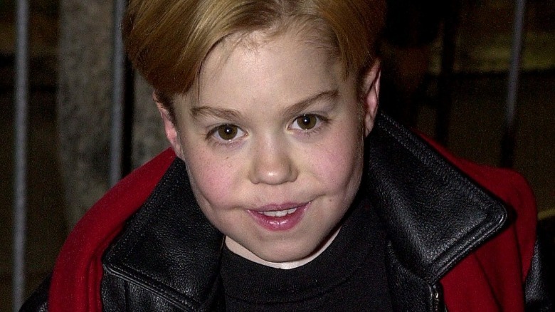 Josh Ryan Evans, wearing leather jacket with red scarf