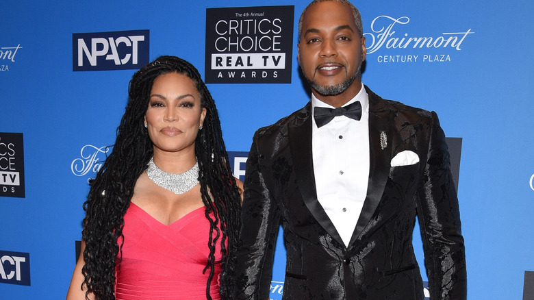 Mike Jackson and Egypt Sherrod wearing formal wear as they stop and pose for a photo