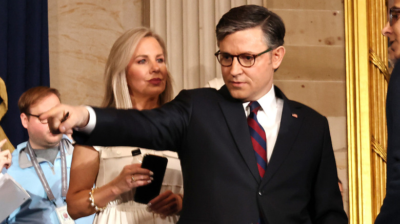 Kelly Lary looks at Mike Johnson as he points to something off-camera.