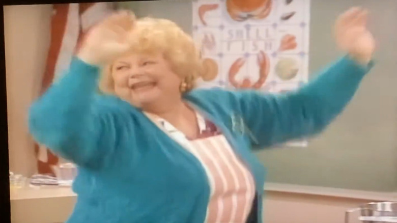 Bunny Summers in character in a blue sweater and striped apron