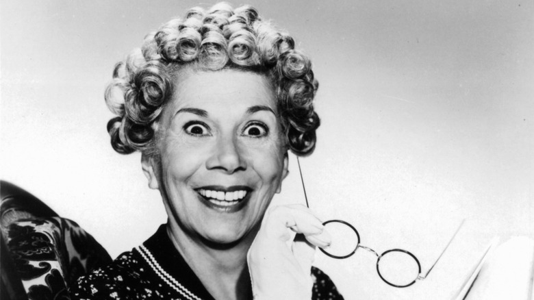 Bea Benaderet holding eyeglasses while posing for a black-and-white picture.