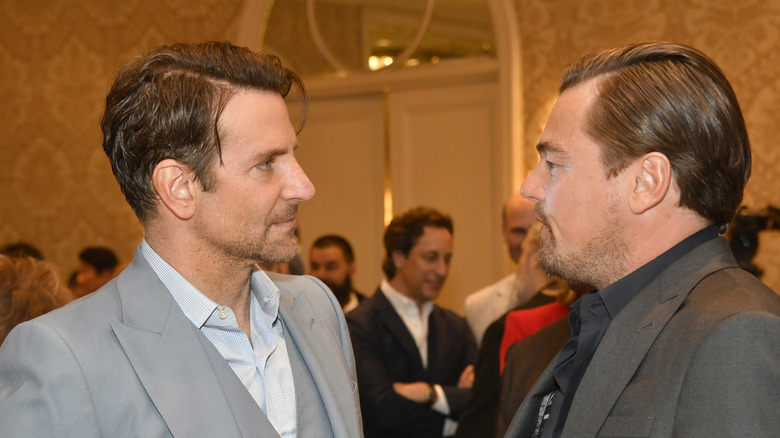 Bradley Cooper listening to Leonardo Dicaprio talk to him