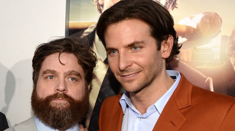 Zach Galifianakis standing next to Bradlery Cooper on the red carpet