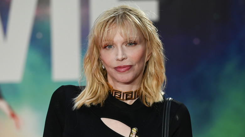 Courtney Love posing in gold choker