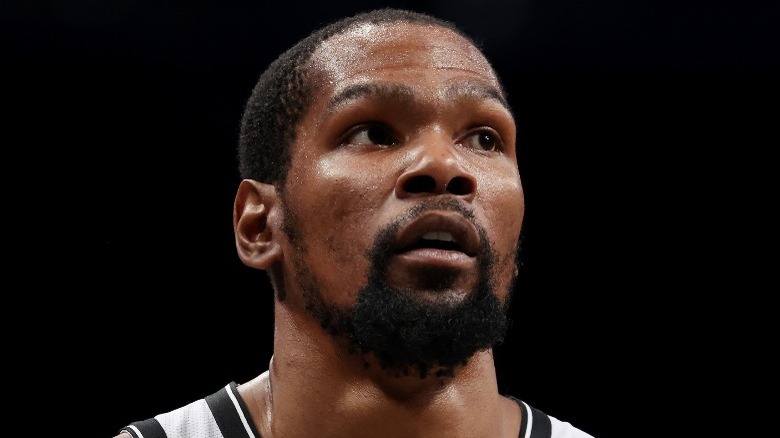 Kevin Durant in his jersey, against a black background