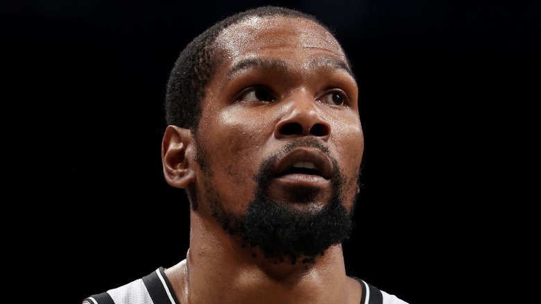 Kevin Durant in his jersey, against a black background