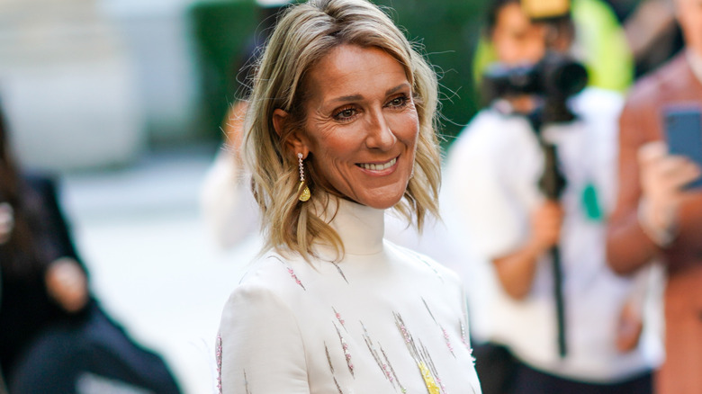 Céline Dion smiling in white turtleneck top