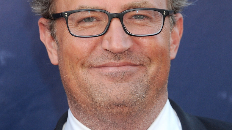 Matthew Perry smiling in glasses