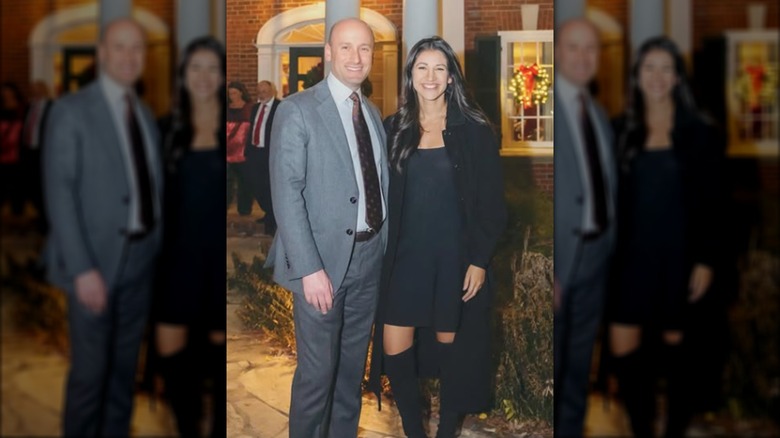 Stephen and Kathie Miller posing together outside a Christmas party.