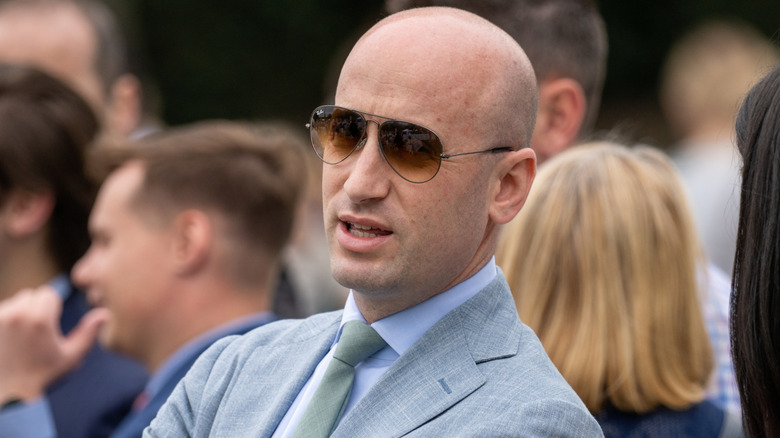 Stephen Miller standing with his arms crossed