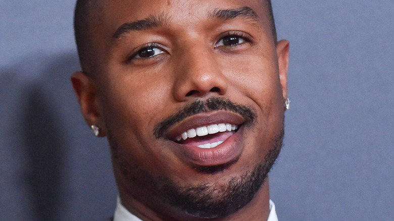 Michael B. Jordan poses in a gray suit