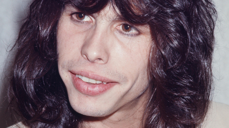 Steven Tyler mid-70s dark hair looking pensive