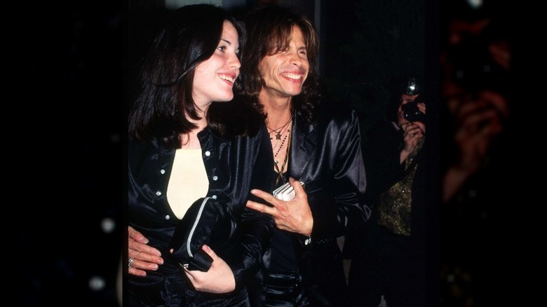Steven Tyler and Liv Tyler posing in matching satin suits 90s